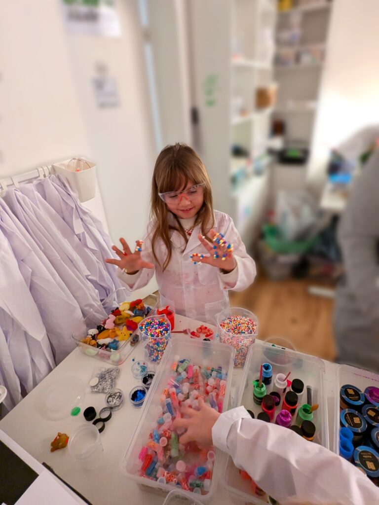 Kind bei Geburtstagsfeier in Action beim Schleimmachen im Laborkittel